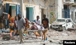 Rescuers carry an unidentified injured man from the scene of an explosion in front of Dayah hotel in Somalia's capital Mogadishu, Jan. 25, 2017.