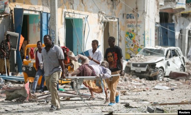 Rescuers carry an unidentified injured man from the scene of an explosion in front of Dayah hotel in Somalia's capital Mogadishu, Jan. 25, 2017.