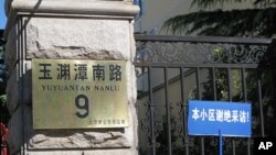 A blue sign taped up to the fence next to the address plaque sign warns reporters that people in this residential compound do not accept interviews. Liu Xia, the wife of the newest Nobel Peace Laureate Liu Xiaobo, lives inside and is reportedly under hou