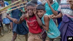 ARSIP – Anak-anak Rohingya Muslim, yang melintasi perbatasan antara Myanmar dan Bangladesh, menangis saat pria-pria Bangladesh mengusir mereka saat pembagian bantuan makanan dekat kamp pengungsi Balukhali (foto: AP Photo/Dar Yasin, Arsip)