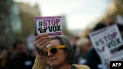Seorang perempuan mengacungkan poster bertuliskan "Stop Vox" dalam unjuk rasa menentang Partai Sayap Kanan Vox in Barcelona, 23 Maret 2019. (Foto: AFP) 