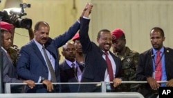 Le président érythréen Isaias Afwerki, deuxième à gauche, et le Premier ministre éthiopien Abiy Ahmed, au centre, se tiennent la main face à la foule à Addis Abeba, en Éthiopie, dimanche 15 juillet 2018. (Photo AP / Mulugeta Ayene)