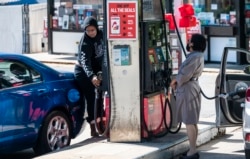 Para pelanggan mobilnya dengan bensin yang masih memiliki persediaan BBM di Arlington, Virgina, 13 Mei 2021. (AFP)