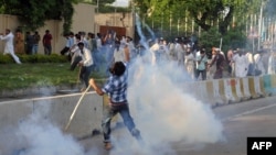 A Pakistani Muslim protester throws a tear gas shell back towards police as demonstrators attempt to reach the U.S. embassy during a protest against an anti-Islam film in Islamabad, September 20, 2012.