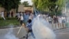  یک معترض پاکستانی گلوله گاز اشک آور را به سوی پلیس پرتاب می کند