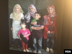 A Syrian refugee family at Zaatari is seen via the portal in New York. (M. Besheer/VOA)