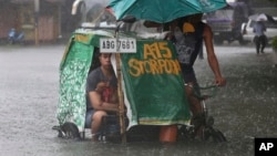 A Filipino man and his dog ride a pedicab along a flooded road in suburban Mandaluyong, east of Manila, Philippines, as monsoon downpours intensify while Typhoon Nepartak exits the country on Friday, July 8, 2016. 
