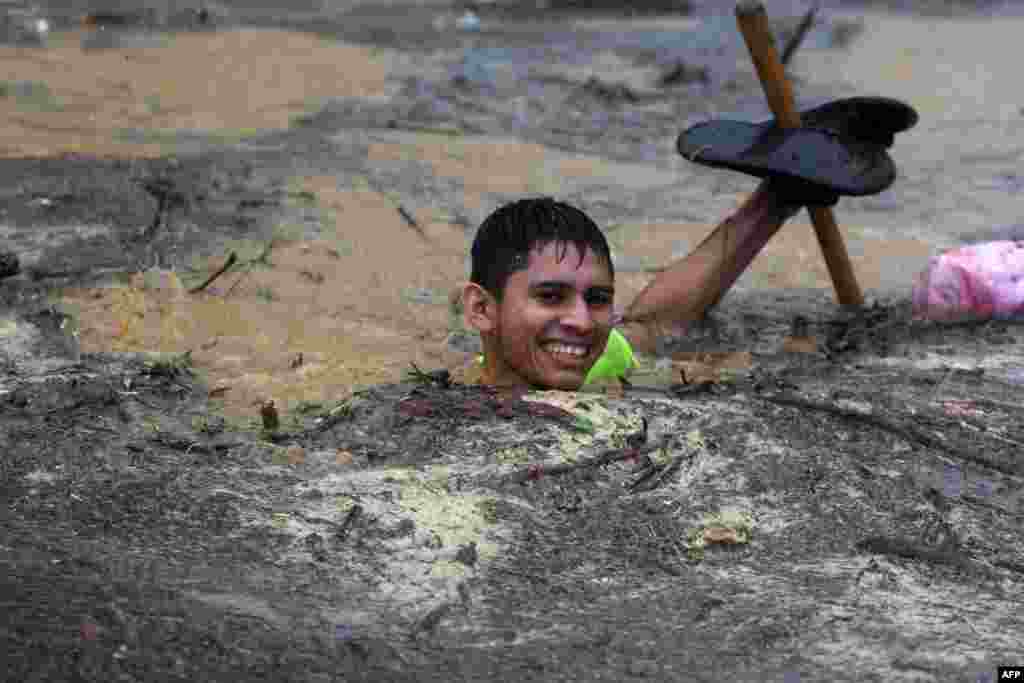 A man wades through flood waters in the Alemania suburb, which was flooded by the overflow of the La Arenera stream, due to the heavy rains caused by Hurricane Eta, in El Progreso, 260 kms north of Tegucigalpa, Honduras, Nov. 4, 2020.