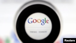 FILE - A Google search page is seen through a magnifying glass in this photo illustration taken in Brussels.