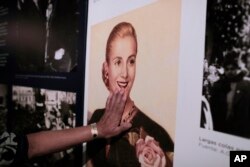 A woman touches a picture of Eva Peron on display at the home-turned-museum "Casa Museo Eva Perón" in Los Toldos, Argentina, May 6, 2019.