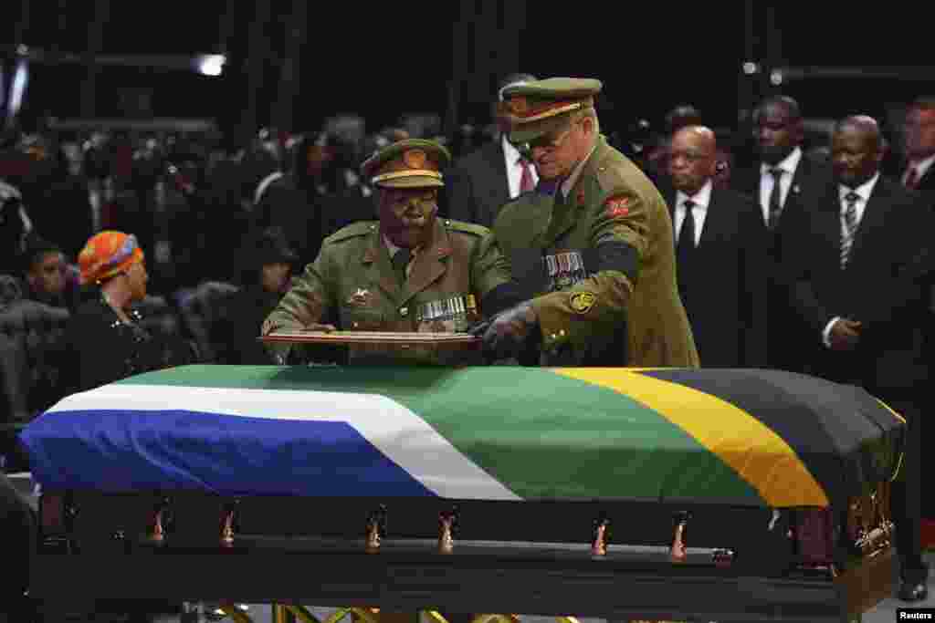 Anggota militer meninggalkan sebuah frame di peti mati mantan presiden Afrika Selatan Nelson Mandela pada upacara pemakaman di Qunu, Afrika Selatan, 15 Desember 2013.
