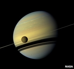 Titan, in front of Saturn, as seen by Cassini