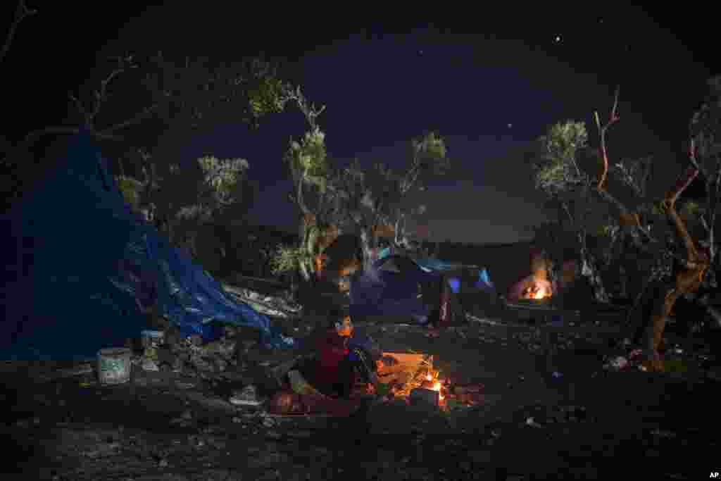 그리스 레스보스섬 북부 모리아 마을에서 아프가니스탄 출신 소년이 추위를 이기기 위해 모닥불을 쬐고 있다.