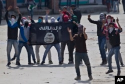 Kashmiri Muslim protesters hold a flag of Islamic State as they shout anti-India slogans during a protest in Srinagar, Indian controlled Kashmir, April 8, 2016.