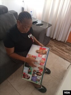 Torkwase Kuraun, Sister of missing journalist Tordue Salem, looks at pictures of him in the family photo album at her home in Abuja, Nov. 4, 2021. (T. Obiezu/VOA)