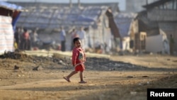 A refugee child from Burma's Bhamo city walks inside a rescue camp in the Chinese southwestern border city of Longchuan, Yunnan province February 10, 2012. In an obscure part of southwest China, a refugee crisis from one of the world's longest running and
