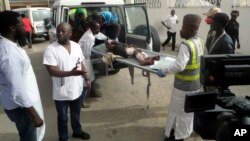 FILE - Health officials loads an injured person into an ambulance following a suicide attack in Damboa, Borno Nigeria, June 17, 2018.