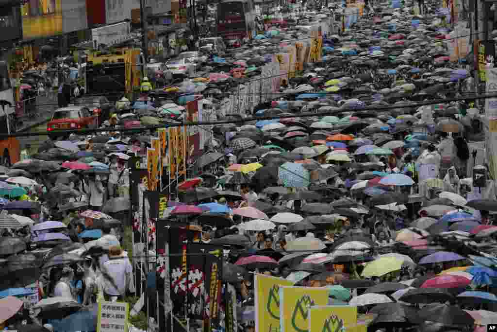 Warga Hong Kong berbaris di jalan dalam protes untuk mendorong demokrasi yang lebih besar (1/7). (AP/Vincent Yu)