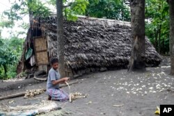 FILE - A woman weaves a mat in a village on Tanna Island in Vanuatu, June 2, 2015. Tanna Island was particularly hard hit by Cyclone Pam, which struck in March of that year. Many people in Vanuatu believed the cyclone was the latest manifestation of climate change's effect on the area.