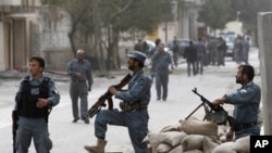 Afghan policemen keep watch at the site of a suicide attack in Kabul September 13, 2011.