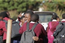 Anak-anak sekolah saling berpelukan di hari terakhir sekolah di Harare, Zimbabwe, Selasa, 24 Maret 2020. (Foto: AP)