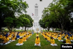 FILE - People practice Falun Gong meditation and exercises before a protest march against the Chinese government, outside City Hall in Los Angeles, Oct. 15, 2015.