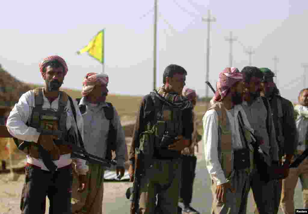 Yazidi fighters who recently joined the Kurdish People's Protection Units (YPG) secure a road in Mount Sinjar in northern Iraq, which is used by displaced people from the Yazidi religious minority fleeing violence from forces loyal to the Islamic State in