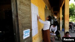 An election worker posts a voter list outside a polling booth at a school in Phnom Penh, Cambodia, July 28, 2018. The main opposition party was banned in November.