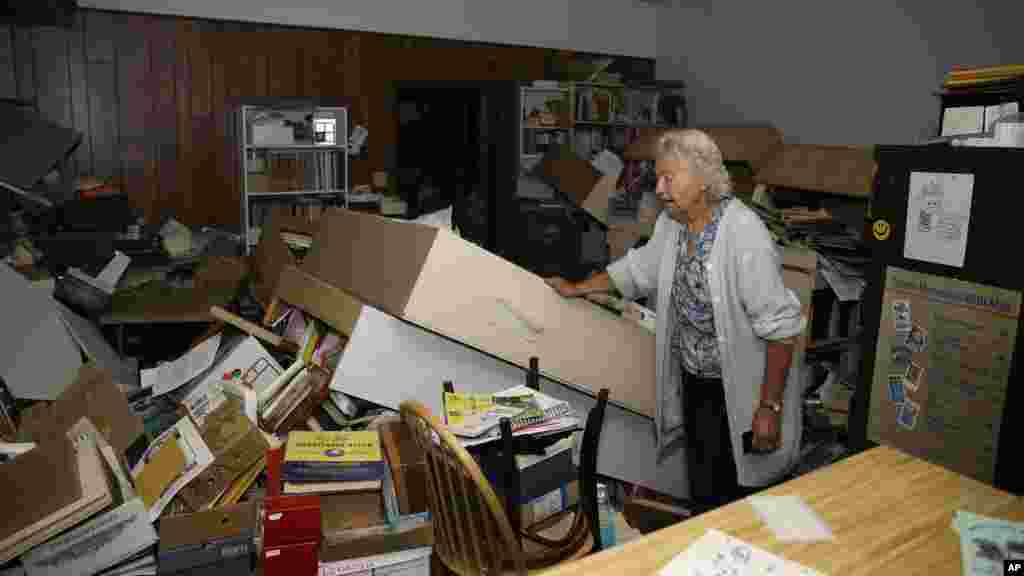 Jean Meehan looks over the damage to her JHM Stamp and Collectibles store following an earthquake in Napa, California, Aug. 24, 2014.