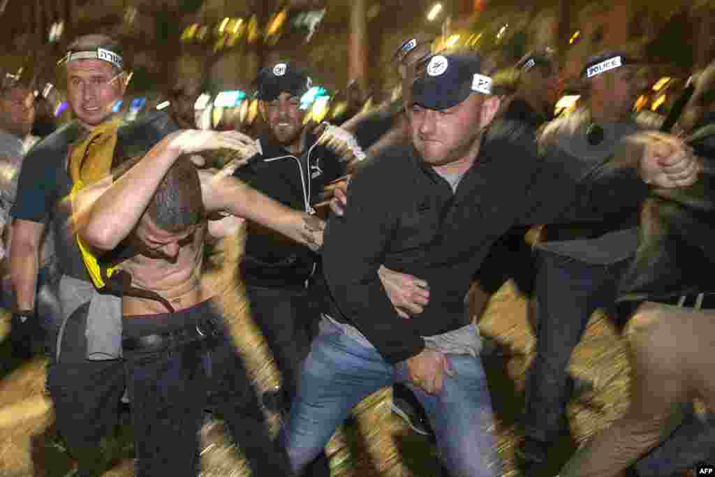 Pasukan keamanan Israel berkelahi dengan seorang demonstran dalam sebuah protes oleh anggota komunitas Ethiopia menentang dugaan kebrutalan polisi dan diskriminasi terlembaga di Tel Aviv, 3 Mei 2015.