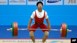 북한의 려은희 선수(왼쪽)가 24일 인천아시안게임 여자 역도 69kg급 경기에 역기를 들고 있다.