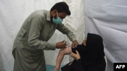 ကရာချိမြို့မှာ ဒေသခံအမျိုးသမီးတဦးကို ကိုဗစ်ကာကွယ်ဆေး ထိုးပေးနေတဲ့ ကျန်းမာရေးဝန်ထမ်း။ (မေ ၃၊ ၂၀၂၁)