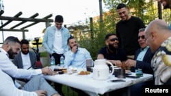 Guests from places within Denmark and Northern Europe sit together at the engagement party of a resident in Mjolnerparken, a housing estate on the Danish government's "Ghetto List," in Copenhagen, Denmark, May 6, 2018.