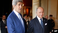U.S. Secretary of State John Kerry, left, is greeted by France's Foreign Minister, Laurent Fabius, in Paris, July 26, 2014.