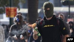 A protester looks at a petrol bomb before throwing it at Athens' main Syntagma Square, during violent demonstrations, October. 20, 2011.