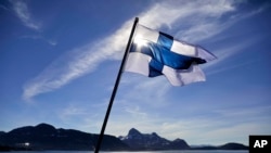 FILE - In this Saturday, July 29, 2017 file photo, Finland's flag flies aboard the Finnish icebreaker MSV Nordica as it arrives into Nuuk, Greenland. Finland has come out on top of an international index that measures nations by how happy they are as plac