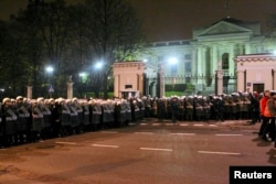 FILE - Riot police form a cordon in front of the Russian embassy during the annual far-right march, which coincides with Poland's national Independence Day, in Warsaw, Nov. 11, 2013.