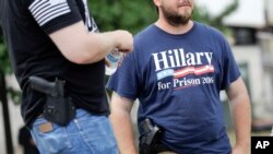 Supporters carrying side arms wait for the start of a rally for Republican presidential candidate Donald Trump at Settlers Landing Park in Cleveland, Ohio, July 18, 2016.