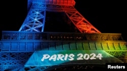 FILE - The Eiffel Tower is lit in the colors of the Olympic flag during the launch of the international campaign for the Paris bid to host the 2024 Olympic Games, in Paris, Feb. 3, 2017. 