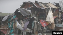 FILE - A squatter's house is pounded as a typhoon hits the coastal town of Bacoor, Cavite southwest of Manila, July 16, 2014.