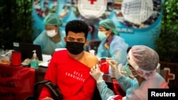 Seorang pekerja migran menerima dosis pertama vaksin Sinopharm melawan COVID-19 di pusat Palang Merah Thailand di Bangkok, Thailand, 5 Oktober 2021. (Foto: REUTERS/Athit Perawongmetha)