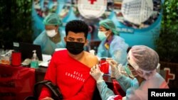 A migrant worker receives his first dose of the Sinopharm vaccine