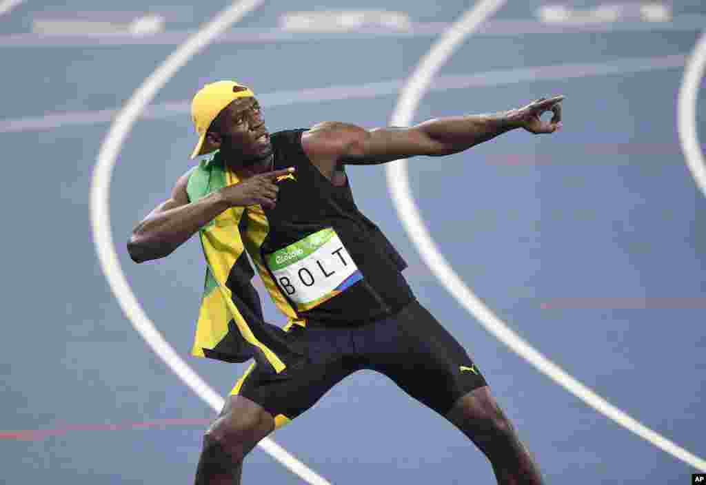 Bolt pose, mimant le mouvement de la foudre, après son 3e sacre consécutif aux 100m aux Jeux Olympiques, à Rio, Brésil, 14 août 2016.