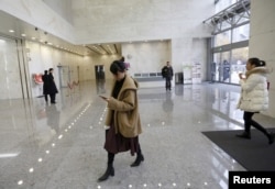在北京某写字楼里走路低头看手机的中国女性