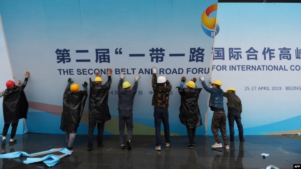 在第二届一带一路国际合作高峰论坛闭幕后，中国工人拆掉宣传板。（2019年4月27日）(photo:VOA)