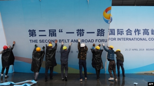 在第二届一带一路国际合作高峰论坛闭幕后,中国工人拆掉宣传板。(2019年4月27日)