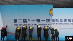 在第二届一带一路国际合作高峰论坛闭幕后，中国工人拆掉宣传板。（2019年4月27日）