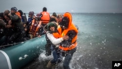 Des réfugiés venus de Turquie débarquant sur une plage de l'ile grecque de Lesbos, après une traversée de la mer Egée, le 12 février 2016. (AP Photo/Santi Palacios, File)