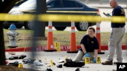 FBI crime scene investigators document the area around two deceased gunmen and their vehicle outside the Curtis Culwell Center in Garland, Texas, May 4, 2015. 
