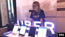 An employee of Uber stands behind a display of Uber technologies, Phnom Penh, Cambodia, September 28, 2017. (Hul Reaksmey/VOA Khmer)